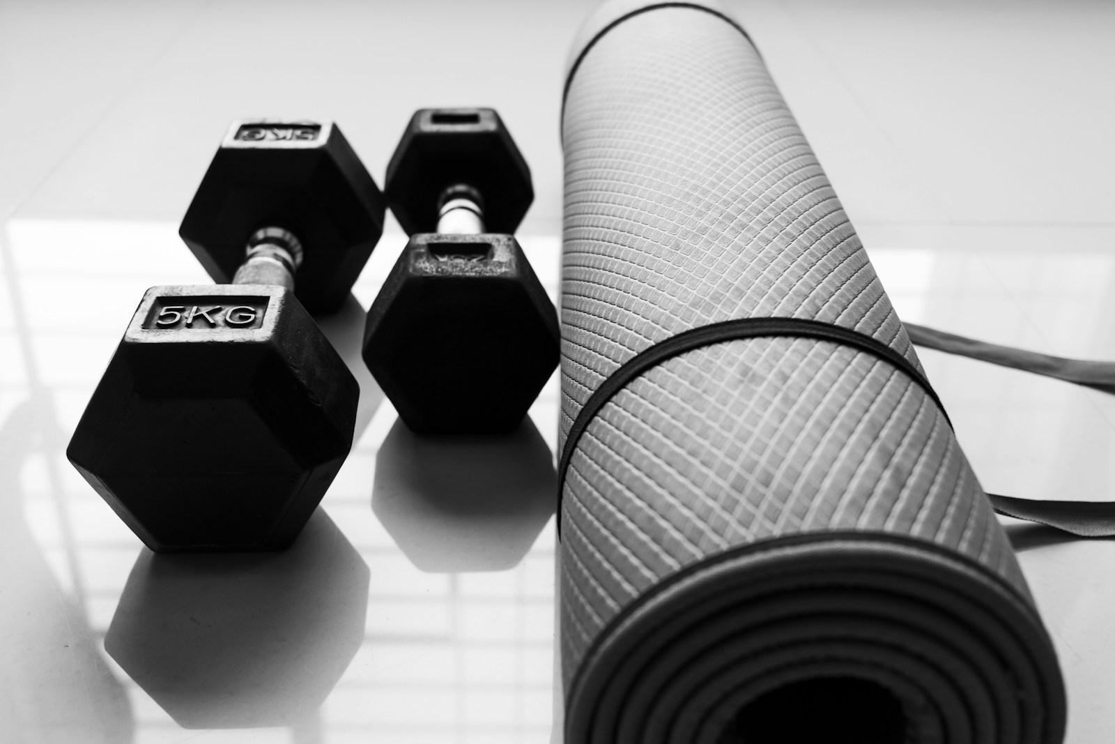 a black and white photo of dumbbells and a yoga mat