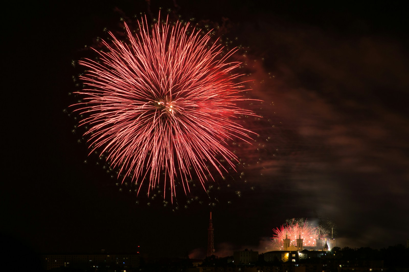 A firework display in the night sky over a city