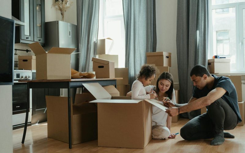 A family unpacks moving boxes in their new home kitchen, creating a cozy atmosphere.